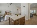 Kitchen island with white countertop, dark wood cabinets, and view into living and dining areas at 7297 E Black Rock Rd, Scottsdale, AZ 85255
