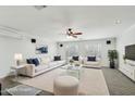 Bright living room with a plush rug, white furnishings, and natural light from shuttered windows at 7546 W Mary Jane Ln, Peoria, AZ 85382
