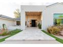 Elegant front entrance with stone pathway, modern chandelier, and sleek design elements at 8230 E Wood Dr, Scottsdale, AZ 85260