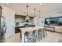 Modern kitchen featuring a large island with seating, pendant lighting, stainless steel appliances, and dark cabinetry at 8251 E Petunia Ave, Mesa, AZ 85212