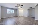 Open-concept living room with laminate flooring, fresh paint, ceiling fan, and bright window at 863 Leisure World --, Mesa, AZ 85206