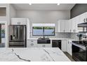 Bright kitchen featuring white cabinets, subway tile backsplash, quartz countertops, and stainless steel appliances at 8913 S Forest Ave, Tempe, AZ 85284
