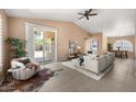 Bright living room features tiled floors, vaulted ceilings, stylish furniture, and sliding glass doors to the patio at 93 S Sandstone St, Gilbert, AZ 85296
