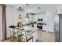 Spacious kitchen featuring a central island with seating, stainless steel appliances, and modern pendant lighting at 9735 W Catalina Dr, Phoenix, AZ 85037