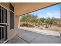 Covered back patio providing a serene view of the desert landscaping and the open backyard at 1029 E Ian Dr, Phoenix, AZ 85042