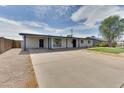 Spacious driveway leading to a home with a covered carport and a modern facade at 1209 E Marigold Ln, Tempe, AZ 85288