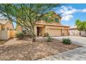 Inviting two-story home with a three-car garage, a red tile roof and easy-care desert landscaping at 1565 E Prickly Pear Pl, Casa Grande, AZ 85122