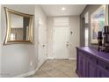 Foyer with bright white door, accented with elegant mirror and decorations at 16514 W Sandia Park Dr, Surprise, AZ 85374