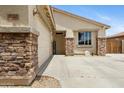 Inviting front entrance with stone pillars, a 'welcome' sign, and convenient garage access at 17292 W Pinnacle Vista Dr, Surprise, AZ 85387