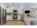 Bright kitchen with stainless steel appliances, white cabinets, and a view into the living area at 17292 W Pinnacle Vista Dr, Surprise, AZ 85387