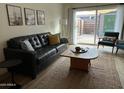 Comfortable living room showcasing a leather sofa, neutral tones, and access to a private patio at 1823 E Kirkland Ln # C, Tempe, AZ 85281