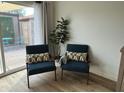 Cozy living room detail with stylish chairs, a plant, and access to a private outdoor patio at 1823 E Kirkland Ln # C, Tempe, AZ 85281