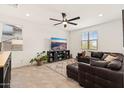 Comfortable living room with tile floors, a ceiling fan, and a leather sectional at 19968 W Flower St, Buckeye, AZ 85396