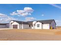 Modern home exterior with multi-car garage and desert landscaping showcases clean lines and simple elegance at 34449 N Elk Run Rd, San Tan Valley, AZ 85143