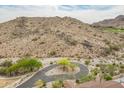Scenic aerial view of desert landscape with winding road, lush green trees, and distant homes at 3545 N Vista Way # 404, Buckeye, AZ 85396