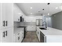 Modern kitchen featuring white cabinetry, stainless steel appliances, and a stylish backsplash at 3623 S 78Th Dr, Phoenix, AZ 85043