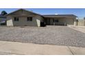Quaint single-story home featuring a gravel front yard and concrete driveway, providing ample parking at 3814 N 55Th Dr, Phoenix, AZ 85031