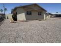Side view of a single-story home with gravel landscaping and a glimpse of the surrounding neighborhood at 3814 N 55Th Dr, Phoenix, AZ 85031