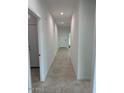 Long hallway with neutral tile flooring leading to the front door of the house at 38150 W Bello Ln, Maricopa, AZ 85138