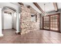Living area with tile floors, stone wall separating the entry, wood beams, and a chandelier at 3913 E Derringer Way, Gilbert, AZ 85297