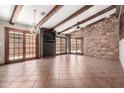 Spacious living room featuring tile flooring, stone accent wall, exposed wood beams and elegant chandelier at 3913 E Derringer Way, Gilbert, AZ 85297