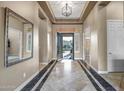 Inviting foyer featuring tile flooring with decorative accents, a modern light fixture, and neutral paint at 42023 N Bridlewood Way, Anthem, AZ 85086