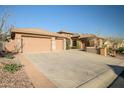 Expansive driveway leading to a three-car garage, complemented by desert landscaping and a serene setting at 42023 N Bridlewood Way, Anthem, AZ 85086