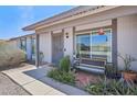 Inviting front porch featuring a bench and stylish landscaping with a security screen door at 5133 E Keresan St, Phoenix, AZ 85044