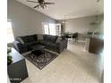 Spacious living room with tile floors, a ceiling fan, and an oversized comfy couch at 7026 S 40Th Pl, Phoenix, AZ 85042