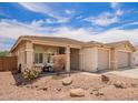 Charming single-story home with a well-manicured lawn, a two-car garage, and a covered front porch at 7241 W Donner Dr, Laveen, AZ 85339
