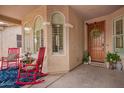 Inviting front porch with rocking chairs, decorative plants, and a charming wooden front door at 7241 W Donner Dr, Laveen, AZ 85339