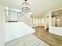 Open foyer with hardwood floors, white walls, staircase, and modern light fixture at 733 E Megan Dr, San Tan Valley, AZ 85140