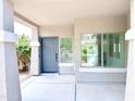 Inviting covered front porch with a blue front door and neutral paint at 733 E Megan Dr, San Tan Valley, AZ 85140