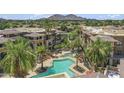 Aerial view of community pools, landscaping, and buildings against a mountain backdrop at 7601 E Indian Bend Rd # 3030, Scottsdale, AZ 85250