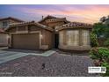 Charming single-story home with a tile roof, bay window, two-car garage, and desert landscaping at 7949 W Wescott Dr, Glendale, AZ 85308