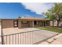 View of the home showcasing the covered parking, gated yard, and well-maintained lawn at 8542 N 30Th Dr, Phoenix, AZ 85051