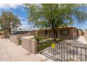 Inviting home exterior with lush tree, gated yard, and 'Do Not Block Driveway' sign at 8542 N 30Th Dr, Phoenix, AZ 85051