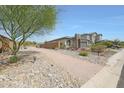 Landscaped home with desert landscaping and a beautiful stone and siding facade at 8683 S 165Th Ave, Goodyear, AZ 85338
