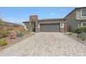 Beautiful home featuring stone accents, a brick driveway, and a two-car garage at 8683 S 165Th Ave, Goodyear, AZ 85338
