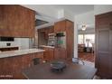 Eat-in kitchen includes stainless appliances, dark wood cabinetry and view into adjacent living space at 8732 E Sandalwood Dr, Scottsdale, AZ 85250