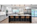 Modern kitchen with white cabinets, a large island with seating, and stainless steel appliances at 9005 W Villa Chula St, Peoria, AZ 85383