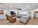 Inviting living room with a large sectional, leather chairs, and a modern entertainment center at 9005 W Villa Chula St, Peoria, AZ 85383