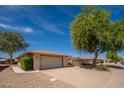 This charming home features a two-car garage, easy desert landscaping, and a shade tree in the front yard at 12831 W Maplewood Dr, Sun City West, AZ 85375