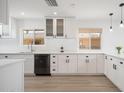 Clean kitchen with white cabinets, stainless-steel dishwasher, and quartz countertops at 12831 W Maplewood Dr, Sun City West, AZ 85375
