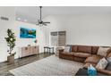 Spacious living room featuring dark wood flooring, a neutral color scheme, a ceiling fan, and lots of natural light at 1320 E Scott Ave, Gilbert, AZ 85234