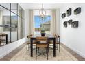 Modern dining room with large windows, contemporary lighting, and seating for eight at 14789 W Lariat Ln, Surprise, AZ 85387