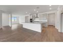 Open concept kitchen and living space with wood-look tile and lots of natural light at 14789 W Lariat Ln, Surprise, AZ 85387