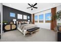 Relaxing main bedroom featuring an accent wall, large windows and a ceiling fan at 14789 W Lariat Ln, Surprise, AZ 85387