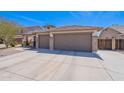 View of the home's garage, with three car spaces and a beautiful front yard at 1520 N Milly Pl, Casa Grande, AZ 85122