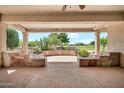 Spacious covered patio with golf course view, stone accents, and desert landscaping at 15534 W Big Sky Dr, Surprise, AZ 85374